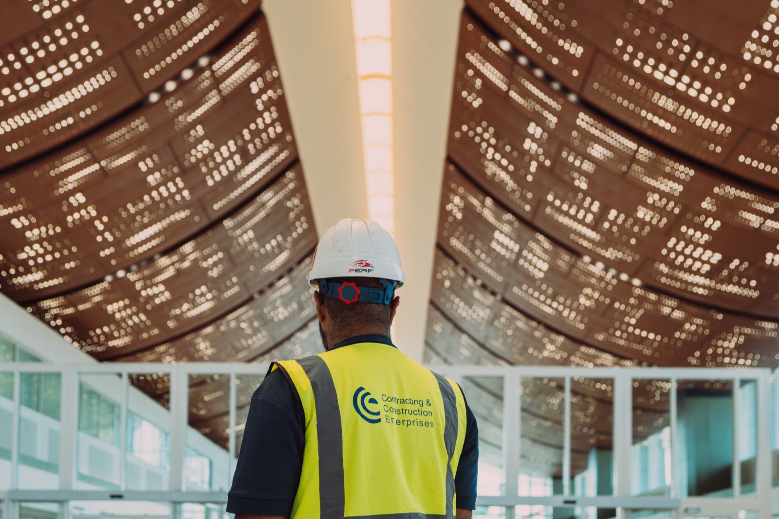 CCE engineer in a hard hat beneath the terminal’s perforated ceiling